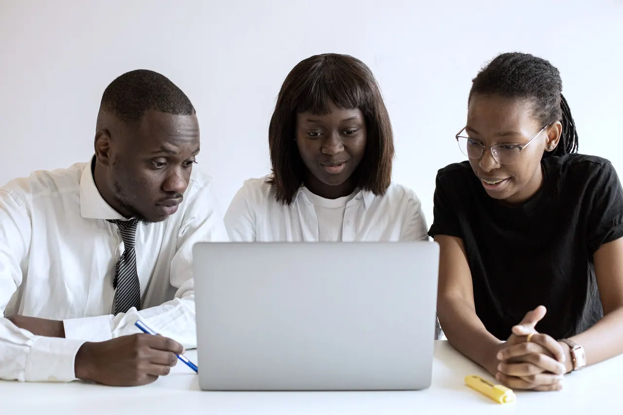 A team planning a project together at a laptop